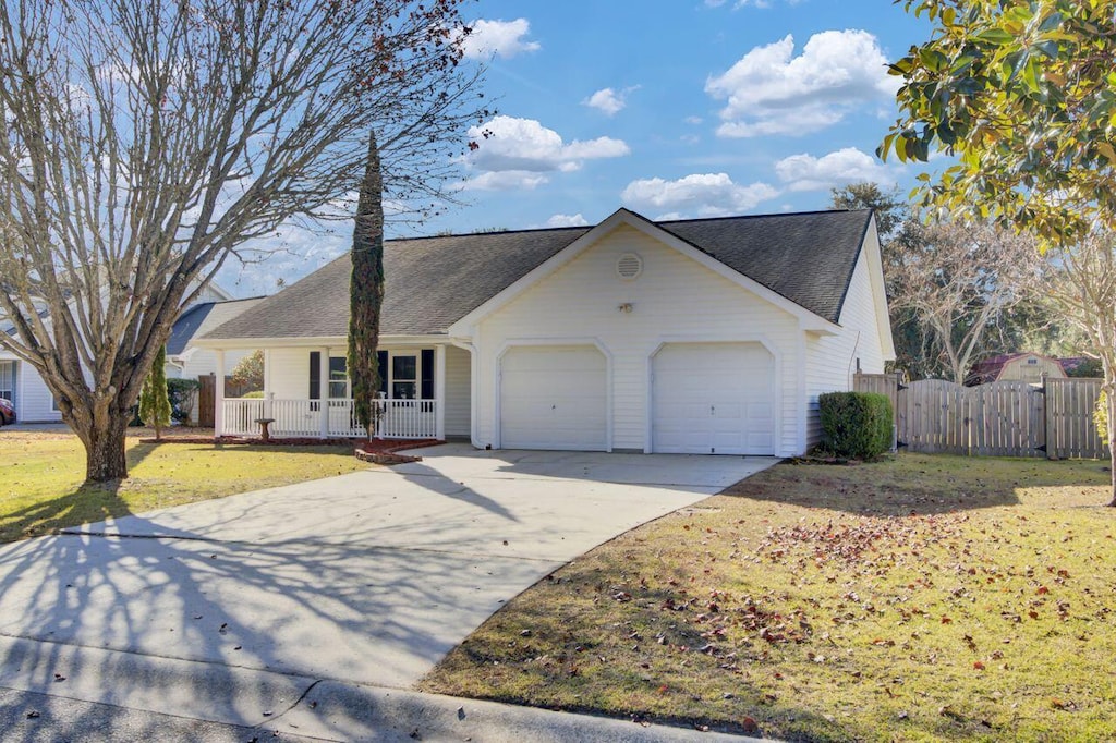 view of front of home featuring a porch, a garage, and a front lawn