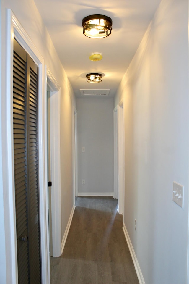 hall featuring baseboards and dark wood finished floors