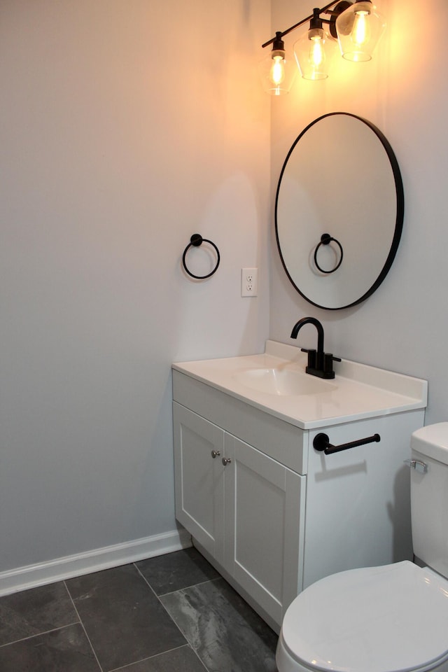 bathroom with vanity, baseboards, and toilet
