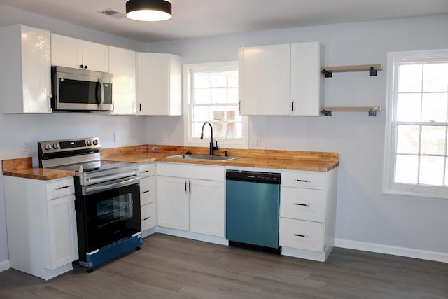 kitchen with wooden counters, visible vents, appliances with stainless steel finishes, open shelves, and a sink