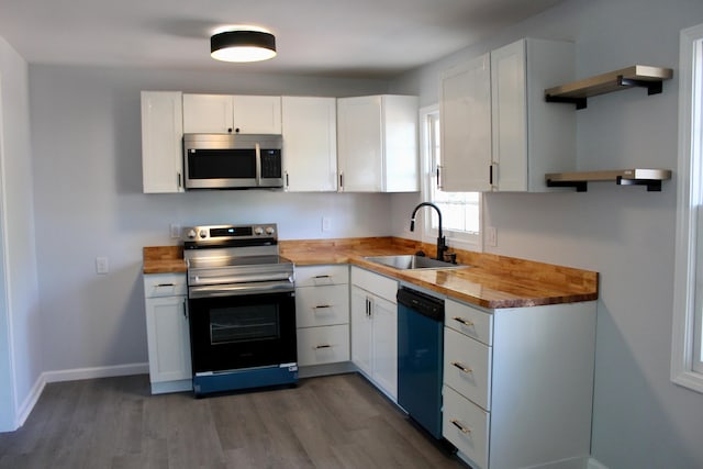 kitchen with open shelves, a sink, wooden counters, and stainless steel appliances