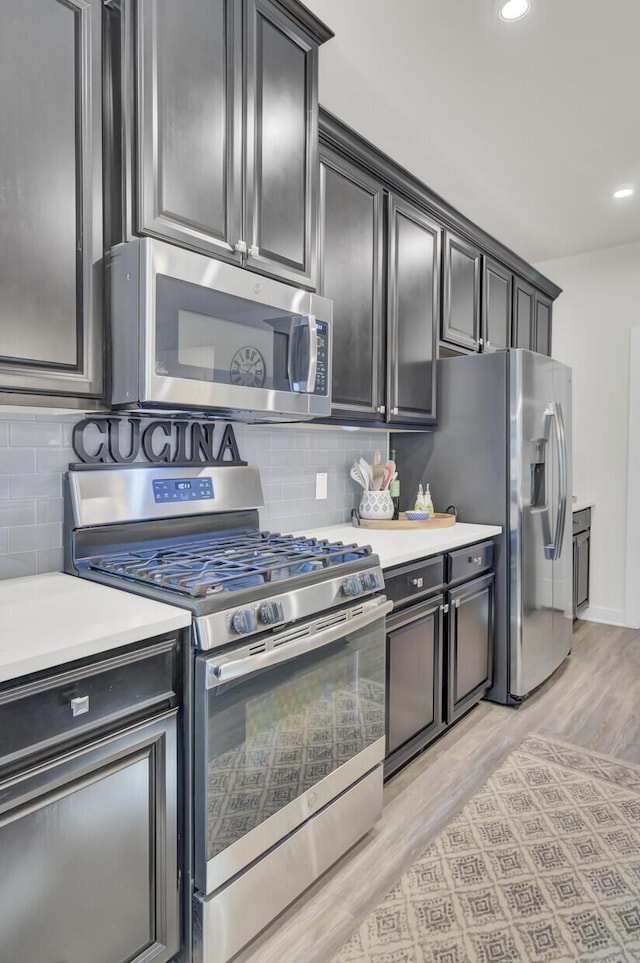 kitchen featuring backsplash, stainless steel appliances, and light hardwood / wood-style floors