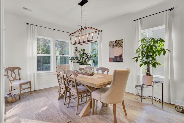 dining area featuring a notable chandelier, plenty of natural light, and light hardwood / wood-style flooring