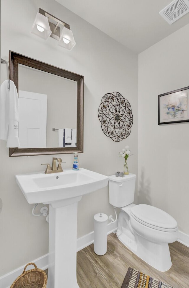 bathroom featuring sink, wood-type flooring, and toilet