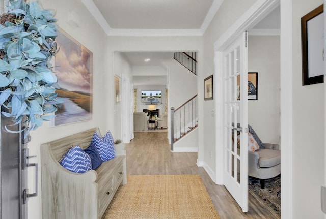 entrance foyer with french doors, light hardwood / wood-style floors, and ornamental molding