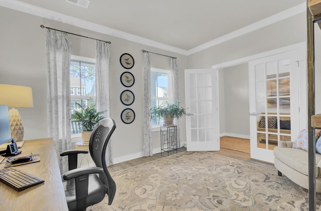 office area with hardwood / wood-style flooring, a healthy amount of sunlight, ornamental molding, and french doors