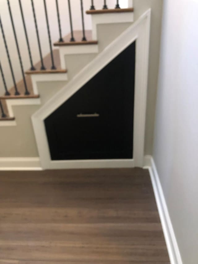 stairway featuring baseboards and wood finished floors