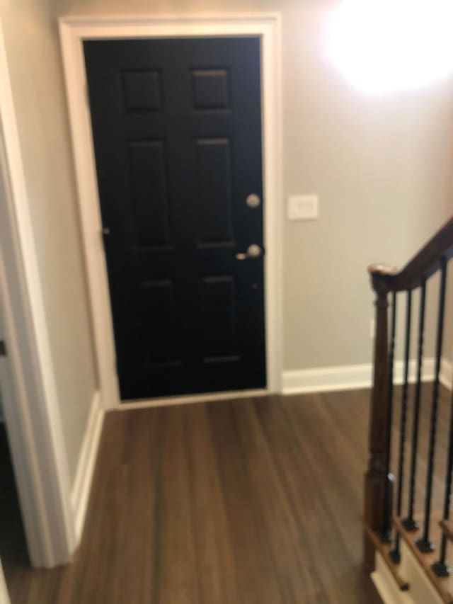 foyer with wood finished floors, stairs, and baseboards