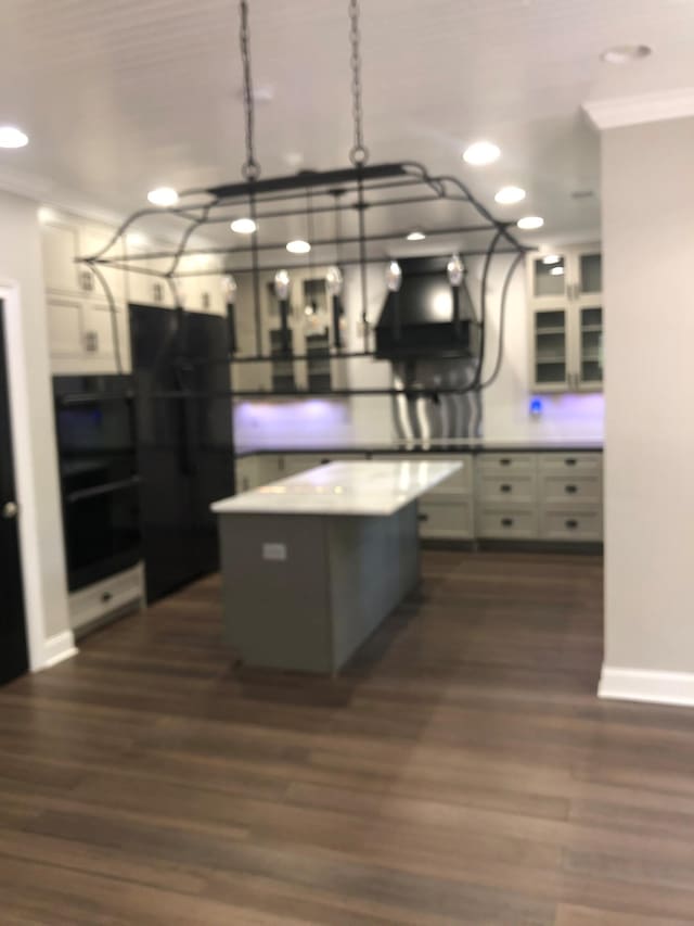 kitchen featuring recessed lighting, dark wood-style flooring, a center island, and crown molding