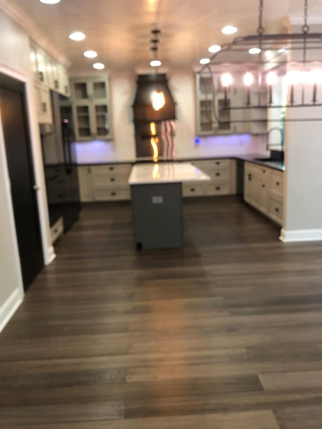 kitchen with recessed lighting, dark wood finished floors, range hood, a sink, and decorative light fixtures