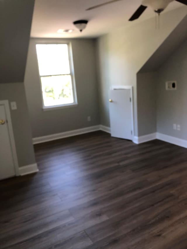 bonus room featuring baseboards and dark wood-type flooring