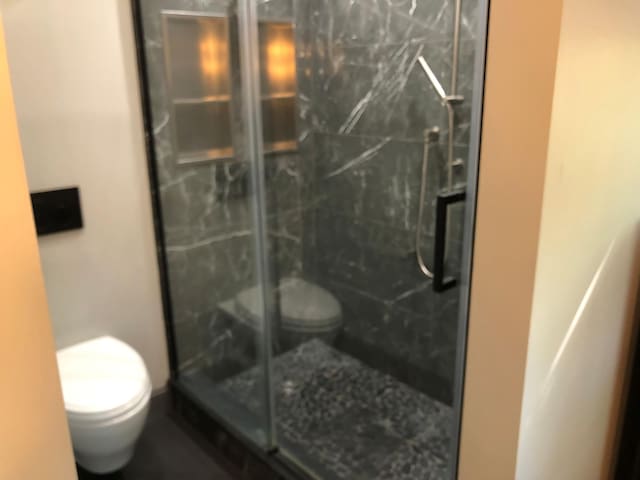 full bathroom with a shower stall and toilet