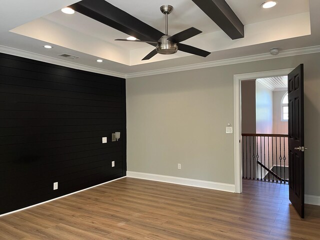 unfurnished room with wood finished floors, visible vents, ornamental molding, baseboards, and ceiling fan