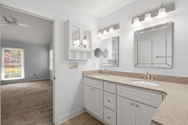 bathroom with double vanity, a ceiling fan, baseboards, and a sink