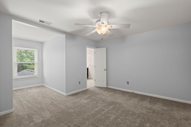 carpeted empty room featuring a ceiling fan, baseboards, and visible vents