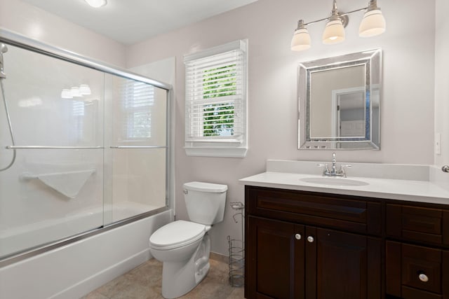 bathroom with vanity, toilet, tile patterned floors, baseboards, and bath / shower combo with glass door
