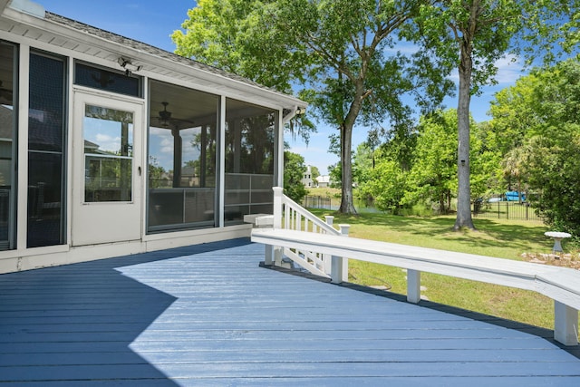 deck featuring a sunroom and a lawn