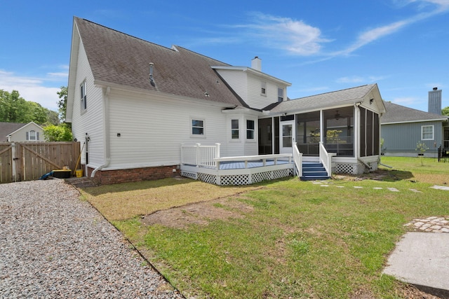 back of house with a chimney, a deck, a sunroom, fence, and a yard