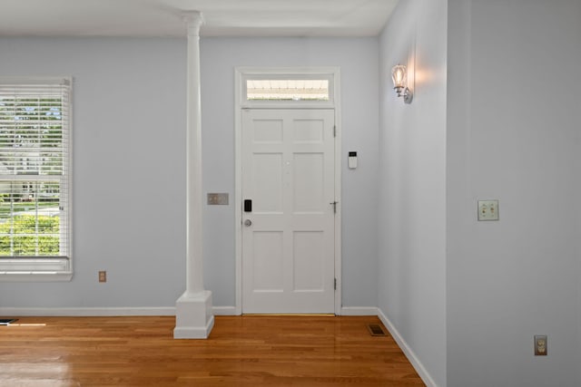 foyer entrance with light wood-type flooring, baseboards, and visible vents