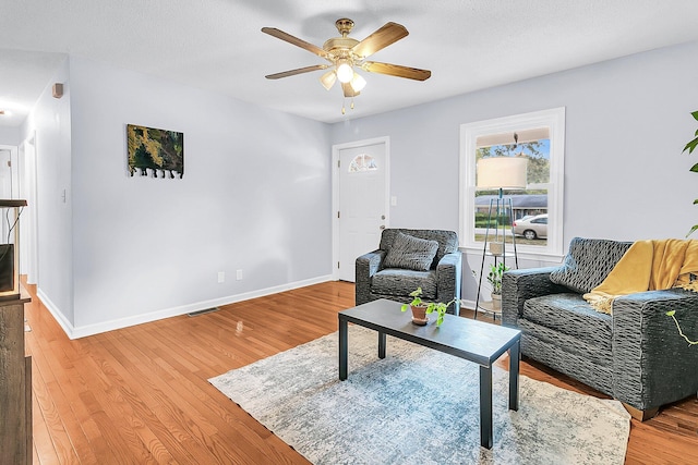 living room with wood-type flooring and ceiling fan