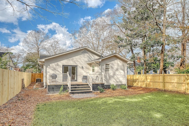 rear view of property with a wooden deck and a lawn