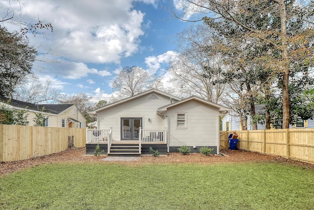 back of house with a wooden deck and a yard