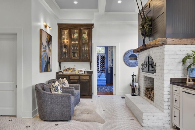 interior space featuring beam ceiling, indoor bar, a brick fireplace, and ornamental molding