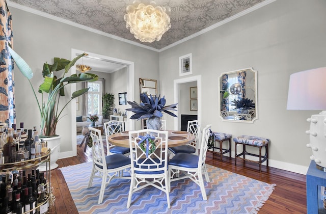 dining room with crown molding, dark hardwood / wood-style flooring, and a notable chandelier