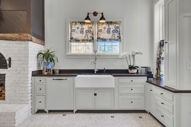 kitchen with white cabinetry, sink, and light tile patterned floors