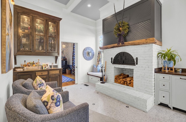 living room featuring coffered ceiling, ornamental molding, a fireplace, bar, and beam ceiling