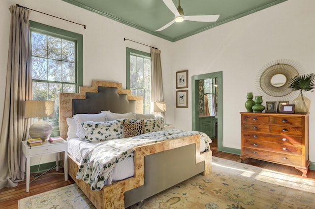 bedroom with ceiling fan, light wood-type flooring, and ornamental molding