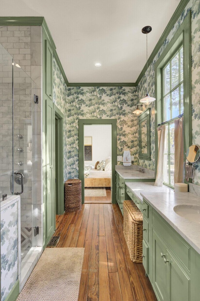 bathroom featuring crown molding, vanity, an enclosed shower, and hardwood / wood-style flooring