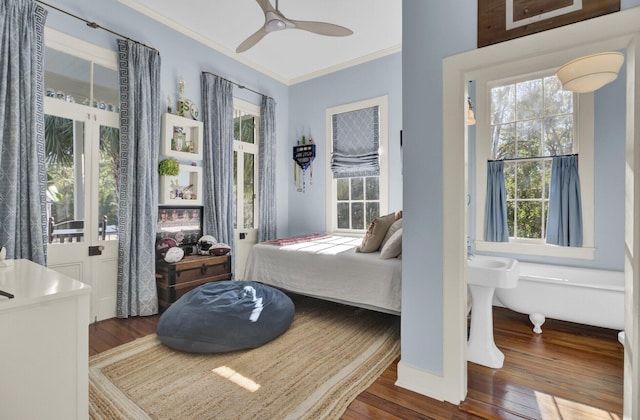 bedroom featuring multiple windows, dark hardwood / wood-style floors, ceiling fan, and ornamental molding