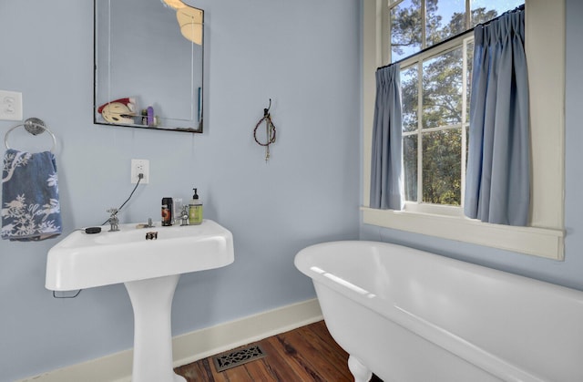 bathroom with hardwood / wood-style flooring and a tub