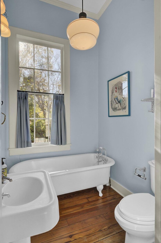 bathroom with hardwood / wood-style floors, toilet, a bathtub, and sink