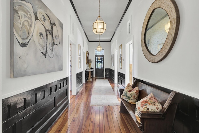 corridor with wood-type flooring and crown molding