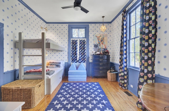 bedroom with ceiling fan, crown molding, and light hardwood / wood-style flooring