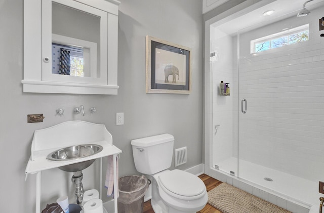 bathroom with toilet, an enclosed shower, wood-type flooring, and sink