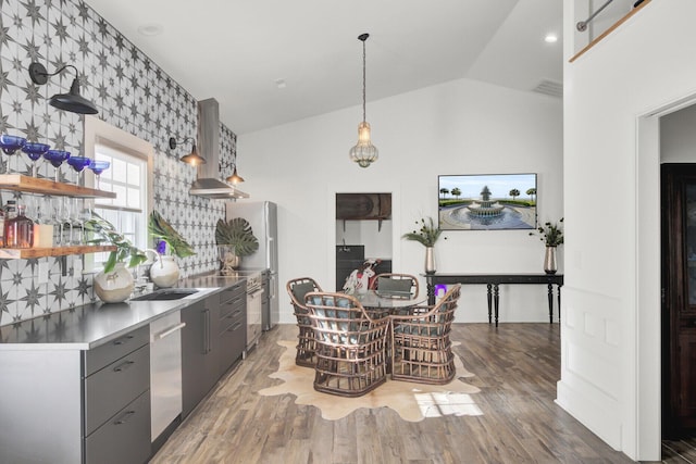 kitchen featuring hardwood / wood-style floors, sink, vaulted ceiling, stainless steel dishwasher, and gray cabinets