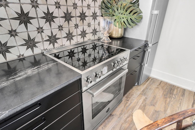 kitchen featuring wood-type flooring, backsplash, and stainless steel appliances