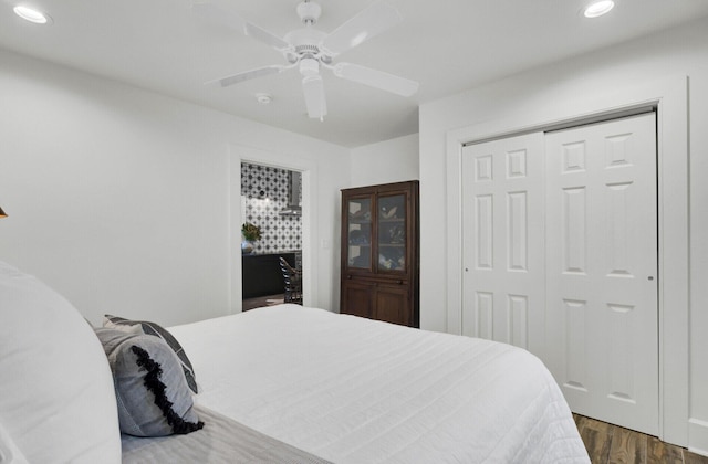 bedroom featuring ceiling fan, dark hardwood / wood-style flooring, and a closet