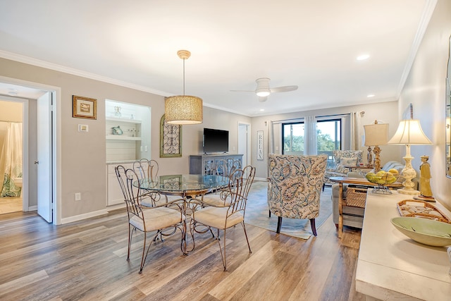 dining space featuring hardwood / wood-style flooring, ceiling fan, and crown molding