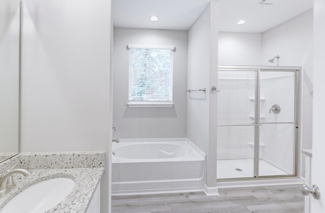 277 W Smith St, Lincolnville, SC 29485 - full bathroom with wood finished floors, a shower stall, a bath, and vanity