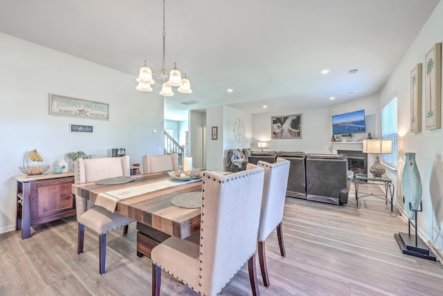 dining area featuring light hardwood / wood-style flooring and a notable chandelier