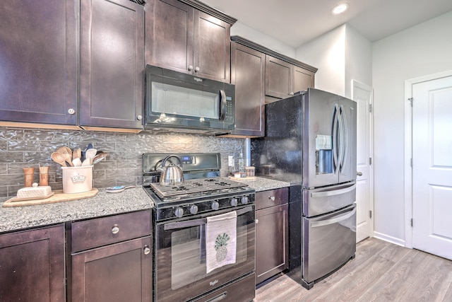 kitchen featuring light stone counters, light hardwood / wood-style floors, decorative backsplash, dark brown cabinets, and appliances with stainless steel finishes