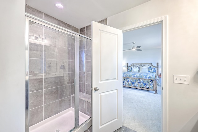 bathroom with ceiling fan and a shower with door