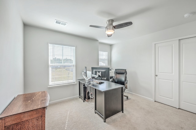 carpeted home office featuring ceiling fan