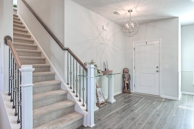 entryway featuring wood-type flooring and an inviting chandelier