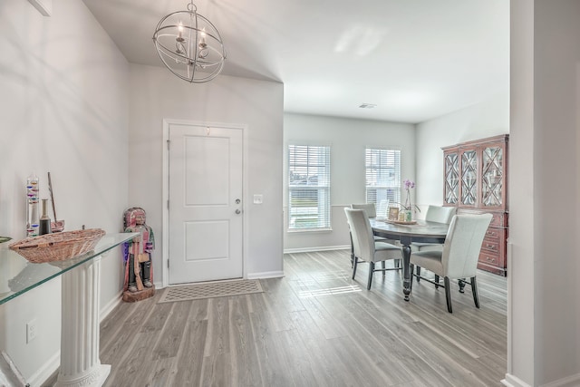 dining room featuring a notable chandelier and light wood-type flooring