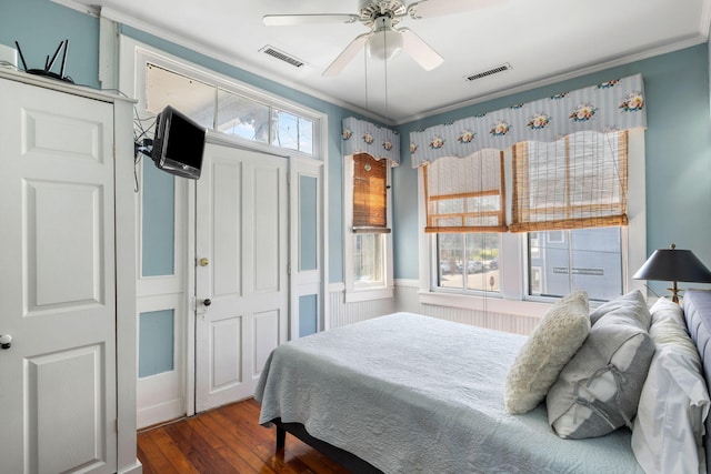 bedroom featuring ceiling fan, ornamental molding, and dark wood-type flooring